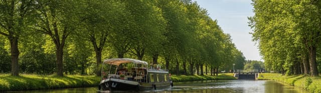 une péniche de plaisance remontant un canal bordé d'arbres par une lumière d'été, écluse en arrière-plan, ambiance crois