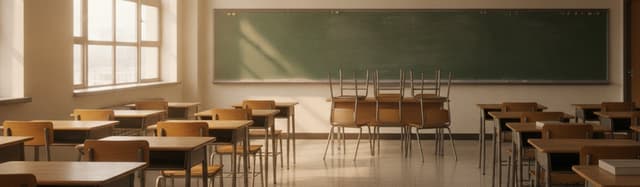 une salle de classe de lycée vide en fin de journée, des tables alignées, un tableau effacé au fond, quelques chaises to
