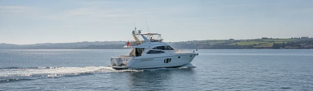 bateau de plaisance à moteur naviguant en mer par temps calme, sans marque ni personne identifiable