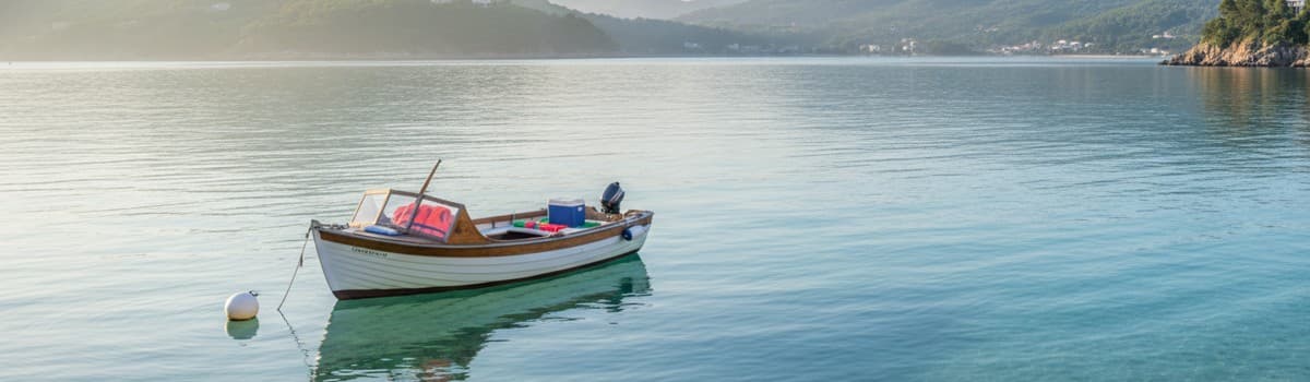 petit bateau de plaisance à moteur au mouillage dans une baie calme, lumière du matin, gilets de sauvetage rangés à bord
