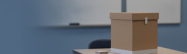 scène éditoriale sobre dans une salle de classe de collège vue de trois quarts, une urne en carton posée sur le bureau d
