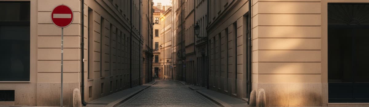 entrée d'une ruelle de centre-ville vue depuis le carrefour, panneau rond rouge à barre blanche fixé sur un poteau au pr