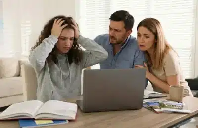Parents et adolescente stressés devant un ordinateur en pleine procédure Parcoursup, illustrant les difficultés et tensions liées à l’orientation post-bac.